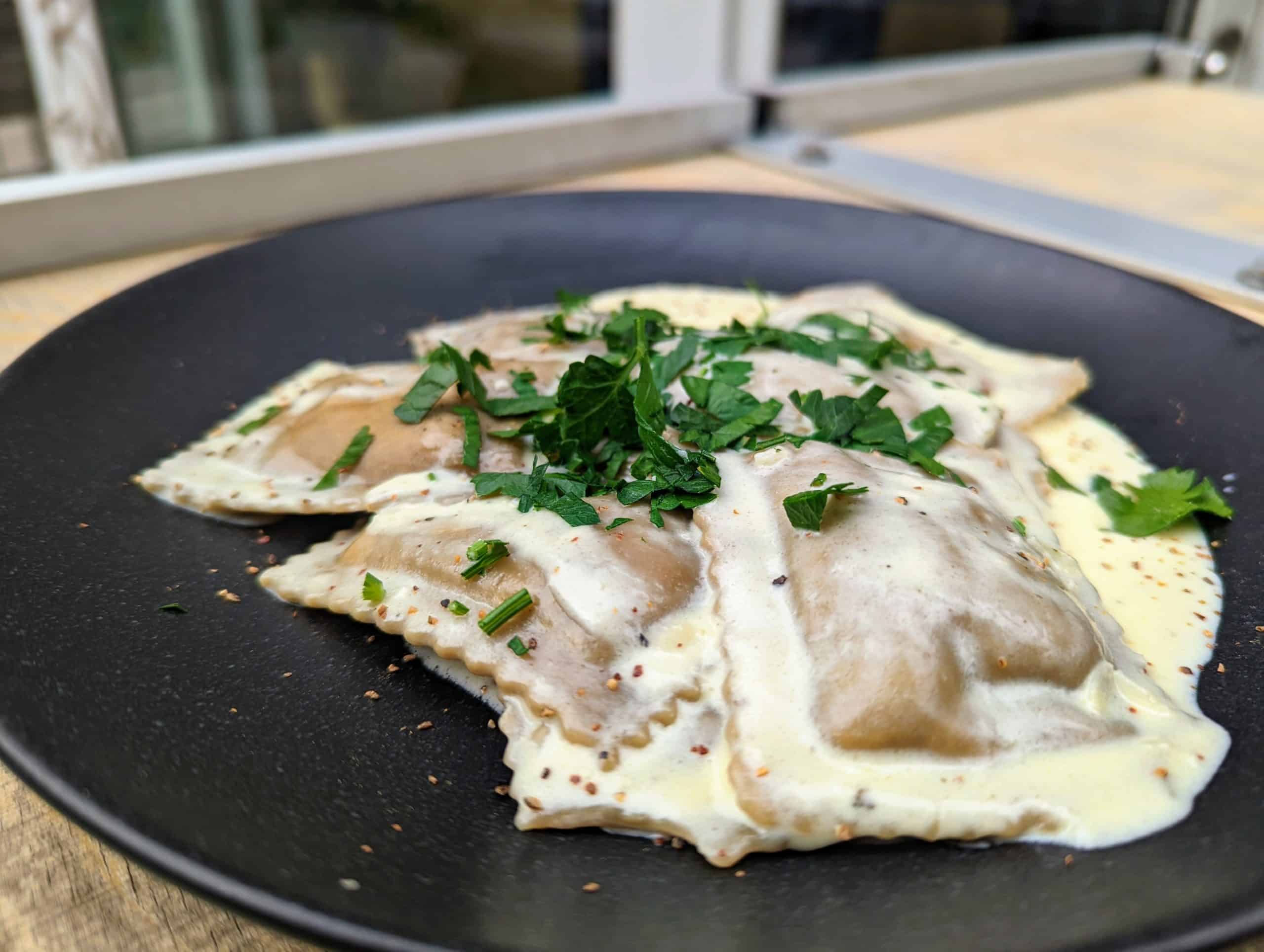 Ravioloni im Steinpilzteig gefüllt mit schwarzem Trüffel in Parmesansauce